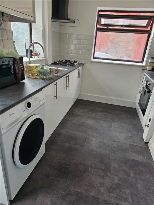 Same galley kitchen after: white gloss units and new flooring