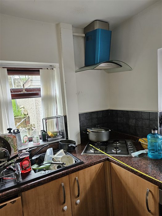 Galley kitchen before: dated wood-effect units