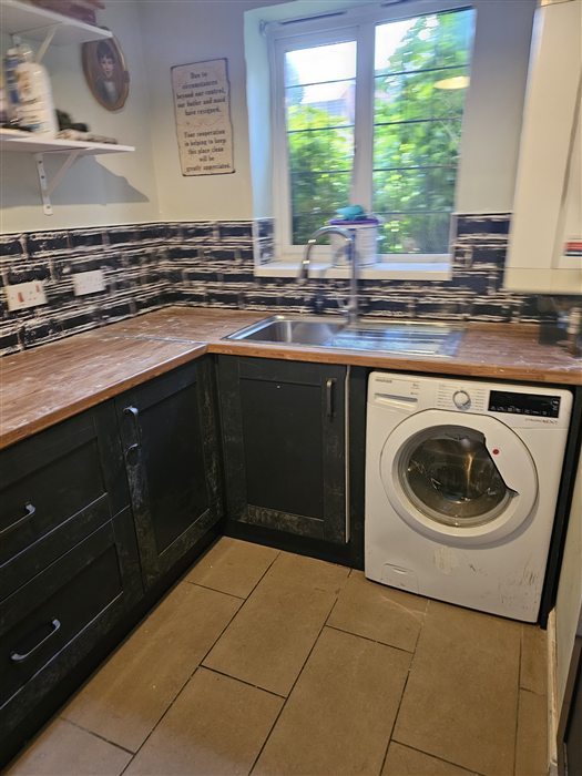 Same kitchen after: navy shaker units, oak-look worktop and metro tiles