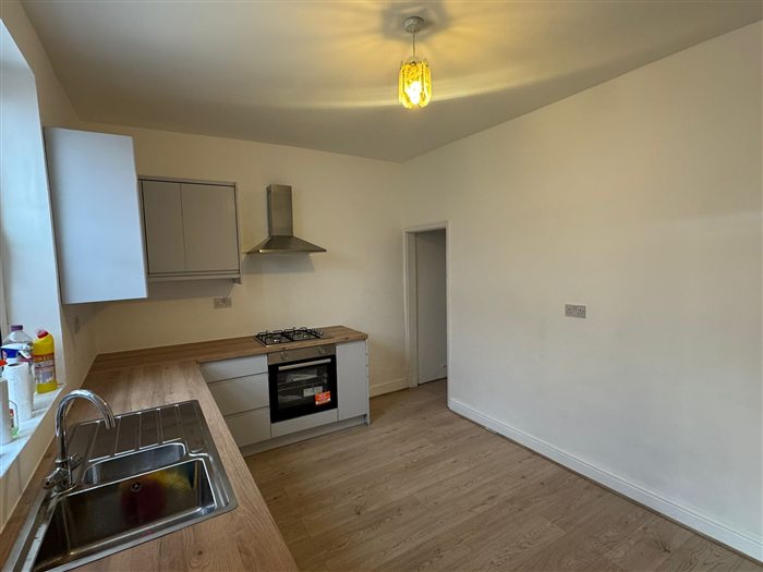 Renovated open kitchen with new flooring and white walls