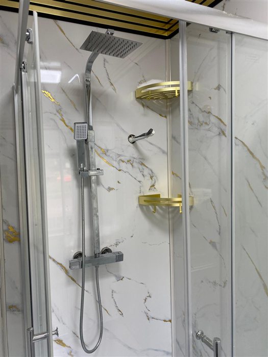 Shower enclosure with marble-effect wall panels and brass shelves