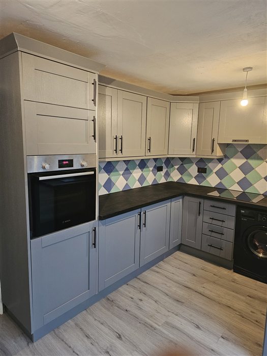 Blue-grey shaker kitchen with patterned tiles