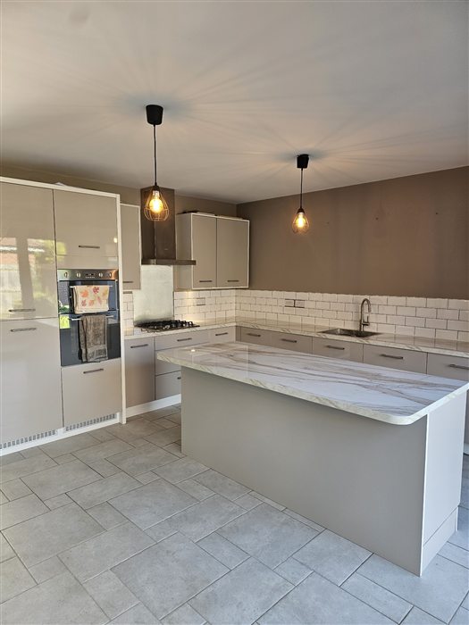 Kitchen with marble-effect island and pendant lights