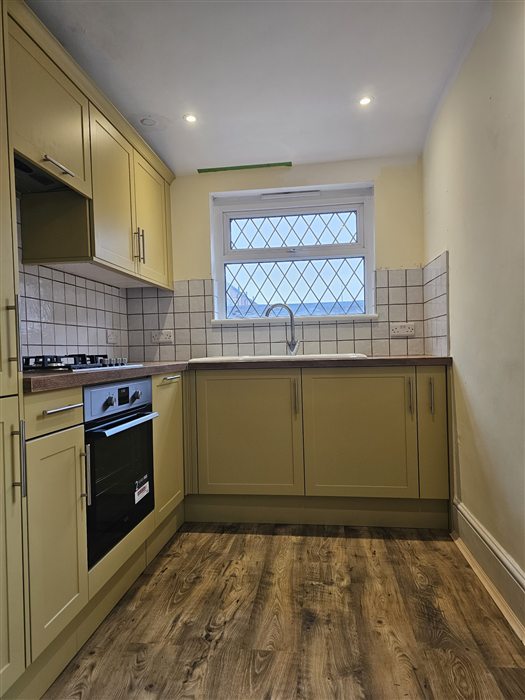 Yellow shaker kitchen seen from the doorway
