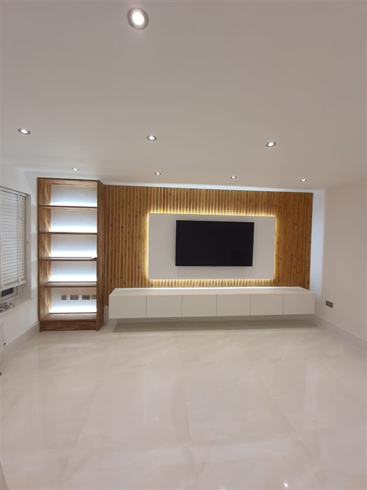 Media wall with oak slat panel and lit display shelves