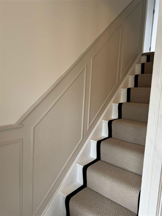 Painted wall panelling running up a staircase