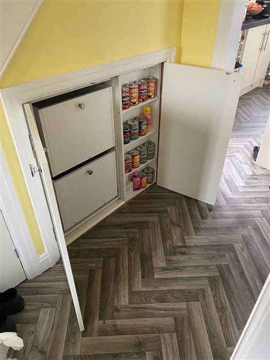 Pull-out drawer storage built into the space under a staircase