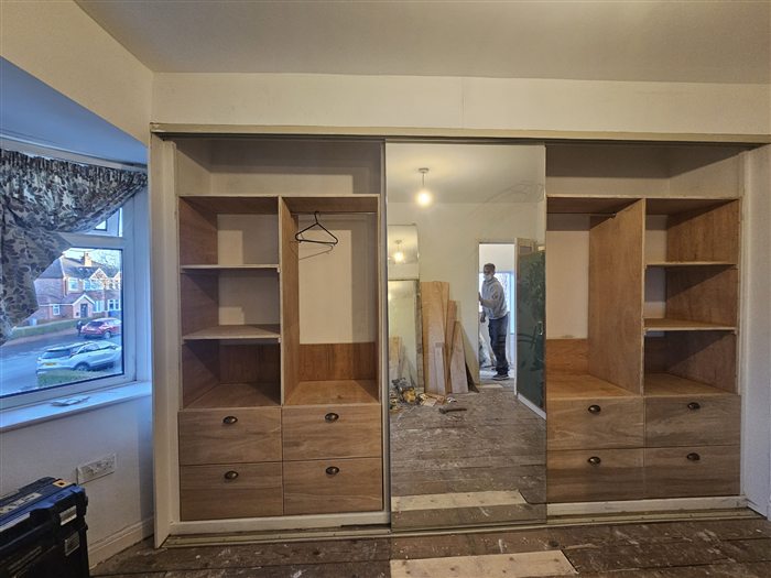 Fitted wardrobe with open shelving, drawers and a mirrored sliding door