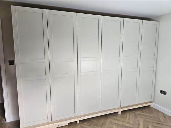 Wall of white shaker-style fitted wardrobes